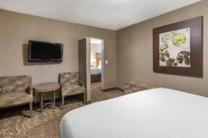 Anaheim Inn hotel room with 2 seperate sleeping areas, tv, table and chairs